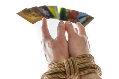 tied with a rope hands and credit cards on white backgroundの写真素材