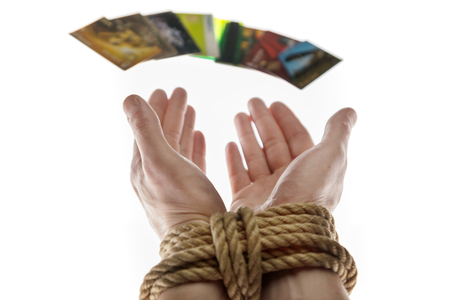 tied with a rope hands and credit cards on white backgroundの写真素材