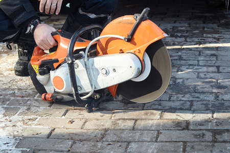 The rescuer checks and starts a petrol circular saw on metalの写真素材