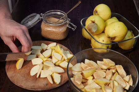 The man cuts a quince and pours it cane sugar