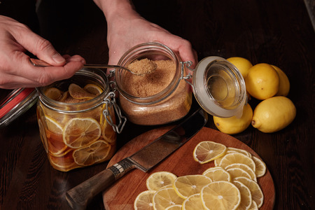 cuts lemons and pours them cane sugarの写真素材