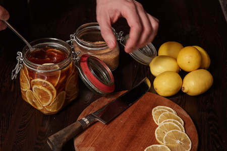 cuts lemons and pours them cane sugarの写真素材