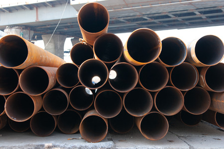 metal pipes lie on the street unprotected from rainfallの写真素材