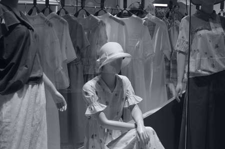 A girl in a hat and a white dress in the shop. Black and white photo.の写真素材