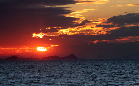 Beautiful sunset in the sea. Dramatic sky with red and orange clouds.の写真素材