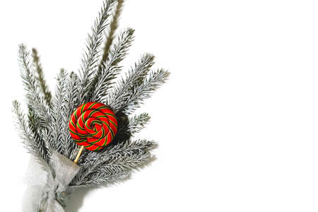 Bouquet of branches of Christmas fir and red candy on a white isolated background. Top view, close-up. There is a place for an inscription. For poster, placard, flyer, congratulations.の写真素材