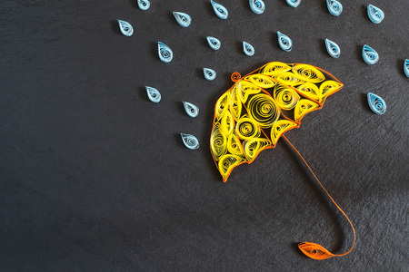 Autumn design details: umbrella and raindrops in the technique of quilling on slate chalkboard with copy spaceの写真素材
