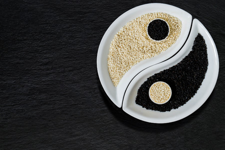 Oriental cuisine ingredients - black and white sesame seeds in the form of Yin Yang symbol
