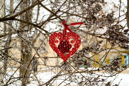 Heart in quilling techniques - symbol of Valentines Day lying on a thick branch of a tree in the winter before the holiday. Selective focusの写真素材