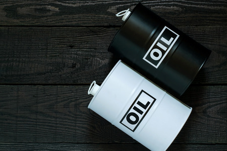 White and black barrels with oil on a wooden backgroundの写真素材