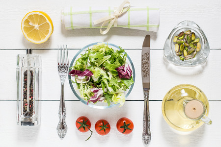 The concept of healthy eating. Ingredients and accessory for the preparation of vitamin salad on a white wooden table. Flat layの写真素材