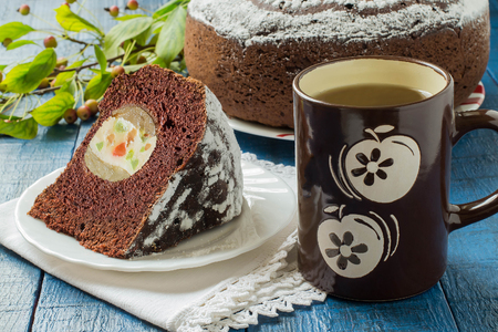 Baking in multicooker. Delicious homemade chocolate cake with whole apples, curd and candied fruit on a blue wooden table. Selective focusの写真素材