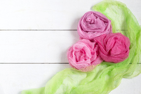 Drape in the form rose of colored gauze on white wooden background. Used in design for decorの写真素材