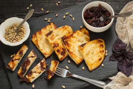 Grilled cheese, served on a slate plate with onion jam and Siberian pine nuts. Adygea cheese (Russia) is used, is prepared according to special technology. You can fry on the grill and frying panの写真素材