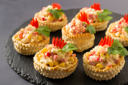 Vol-au-vent with chicken salad, sweet pepper, egg and corn. Festive appetizer for Christmas, Valentine's Day, Easter. Colorful snack of French cuisine from puff pastry with filling. Selective focusの写真素材