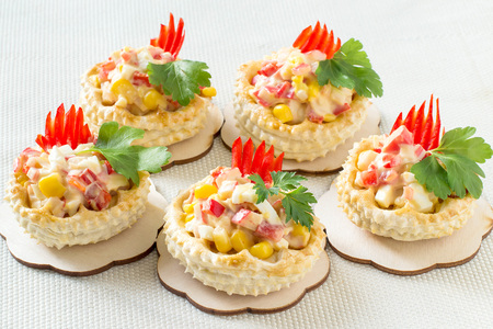 Vol-au-vent filled with chicken salad, sweet pepper, egg and corn. Festive appetizer for Christmas, Valentine's Day, Easter. Colorful snack of French cuisine from air puff pastry with fillingの写真素材