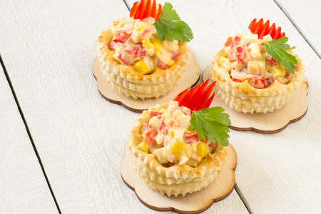 Vol-au-vent filled with chicken salad, sweet pepper, egg and corn. Festive appetizer for Christmas, Valentine's Day, Easter. Colorful snack of French cuisine from air puff pastry with fillingの写真素材
