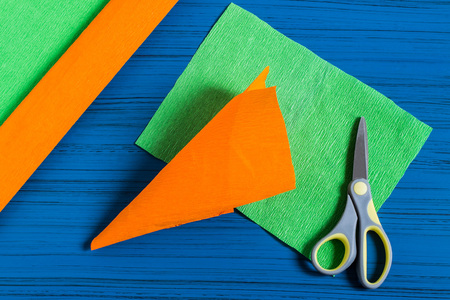 Making package in form of carrots for Easter bunny. Sweet gift to children. DIY concept. Step by step photo instructions. Step 3. Make cone of orange paperの写真素材