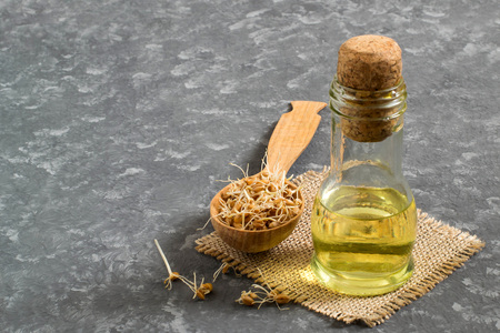 Fresh sprouted wheat seeds in spoon, wheat germ oil in bottle. Source of vitamins and micronutrients, has general strengthening, immunostimulating, antibacterial, antioxidant propertiesの写真素材