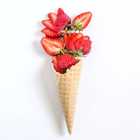 Bouquet of strawberries in waffle cone. Minimal style. Concept of delicious summer dessertsの写真素材