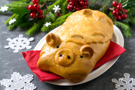 Delicious pie with meat in form of funny pig by New Year. 2019 year of yellow pig on eastern calendarの写真素材