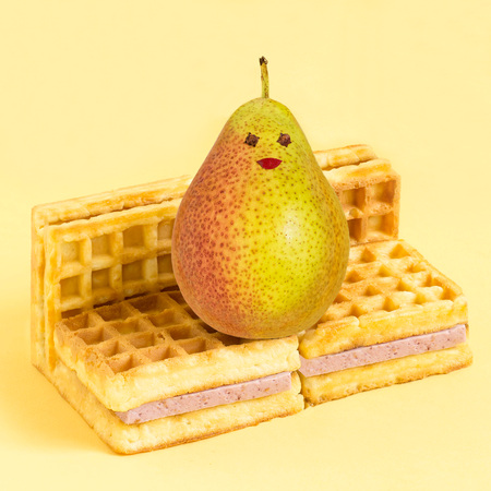 Wafers with blueberry souffle in form of sofa and pear. Minimalist style. Creative idea, imagination and fantasy. Attraction of attention to the problems of physical inactivity and abuse of sweetの写真素材