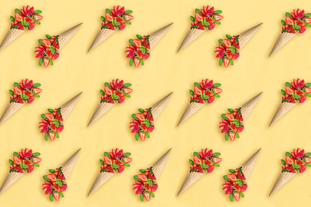 Yellow background with strawberry and mint in waffle cone. Minimal style. Concept of delicious...