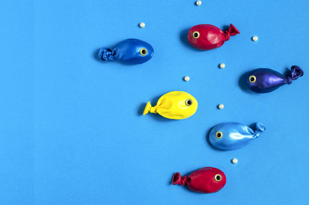 Funny fishes made from colorful balloons. Creative idea, imagination and fantasy. Original children's art concept. Minimal style. Copy spaceの写真素材