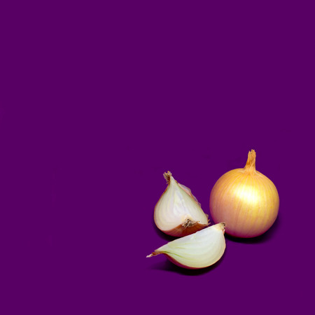 Fresh juicy onions. Whole onions and slices on purple background. Minimal styleの写真素材