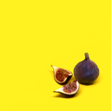 Fresh ripe fig. Whole figs and slices on yellow background. Minimal styleの写真素材