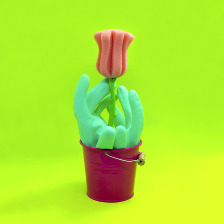 Bucket with rubber gloves and sponge in shape of flower for cleaning. Concept of spring cleaning....