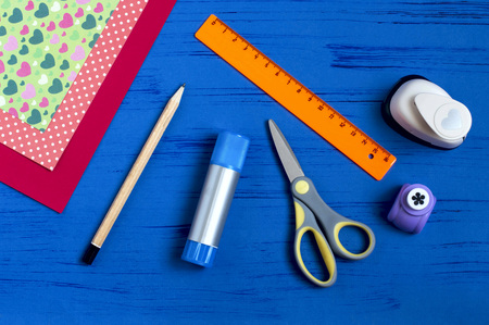 Making greeting card for Valentine's Day. DIY art concept. Step-by-step photo instruction. Step 1. Preparation of materials and tools: paper, scissors, glue, punch, pencil, rule.の写真素材