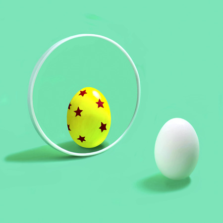 White egg with color decorated reflection in mirror. Creative fantasy on Easter decor. Minimal Easter conceptの写真素材