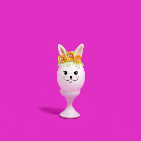 Cute handmade easter bunny made of egg on wooden stand. Creative Easter decor, kawaii style. Minimal easter conceptの写真素材