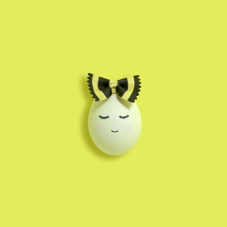 Handmade cute girl made of egg from bow of pasta farfalle. Bicolor pasta farfalle with cuttlefish...