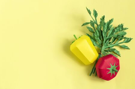 Colorful volumetric tomato, pepper and parsley on yellow background. Paper art and craft. Trendy hobby. Creative, vegetarian, healthy or food art conceptの写真素材