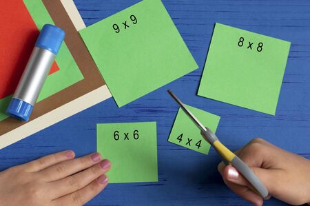 How to make Christmas card with Christmas tree. Original children's art project. DIY concept. Step-by-step photo instructions. Step 2. Cut squaresの写真素材