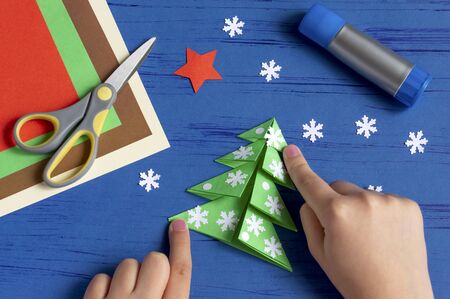 How to make Christmas card with Christmas tree. Original children's art project. DIY concept. Step-by-step photo instructions. Step 9. Glue decorations on Christmas treeの写真素材