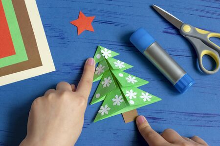 How to make Christmas card with Christmas tree. Original children's art project. DIY concept. Step-by-step photo instructions. Step 10. Glue tree trunkの写真素材