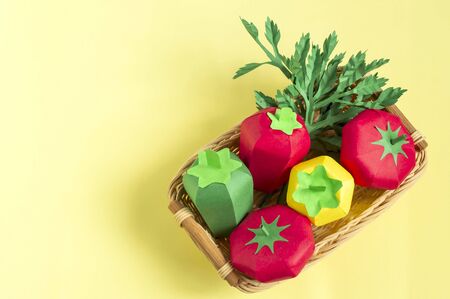 Colorful volumetric paper tomatoes, peppers and parsley in wicker tray. Paper art and craft. Trendy hobby. Creative, vegetarian, healthy or food art conceptの写真素材