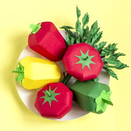 Colorful volumetric paper tomatoes, peppers and parsley on paper plate. Paper art and craft. Trendy hobby. Creative, vegetarian, healthy or food art conceptの写真素材