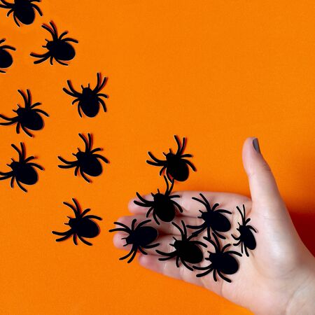 Female hand let go paper spiders. Paper art and paper craft. Festive Halloween conceptの写真素材
