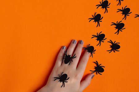 Paper spiders crawling on women's hand. Paper art and paper craft. Festive Halloween conceptの写真素材
