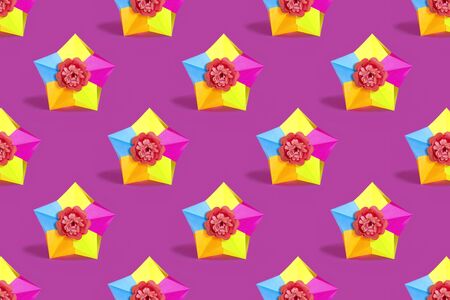 Background of origami stars with paper flower in center. Seamless bright pattern of paper stars. Volumetric handmade paper object. Modern paper art and craft. Minimal decorative conceptの写真素材