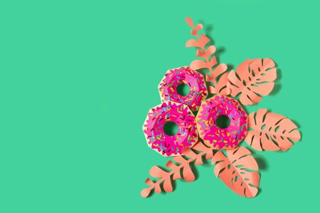 Paper donuts with pink icing and pink leaves. Volumetric handmade paper objects. Summer design. Paper art and craft. Trendy hobby. Minimal art food concept. Copy spaceの写真素材