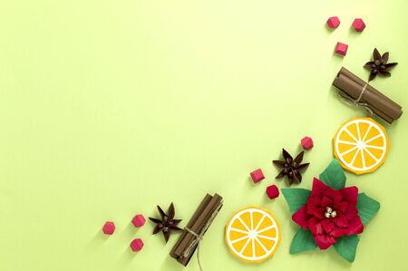 Vignette of paper Christmas decorations. Poinsettia flowers, orange slices, berries, cinnamon sticks...