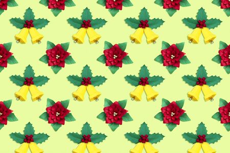 Background of paper poinsettia flowers and Christmas bells with holly branch. Paper art and craft in festive design. Volumetric paper handmade objectsの写真素材