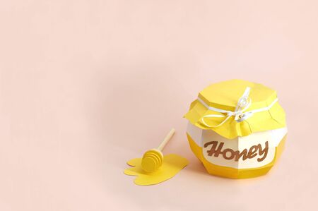 Paper pot with honey and dipper in spreading honey. Paper art and craft. Volumetric handmade paper objects. Minimal healthy eating conceptの写真素材