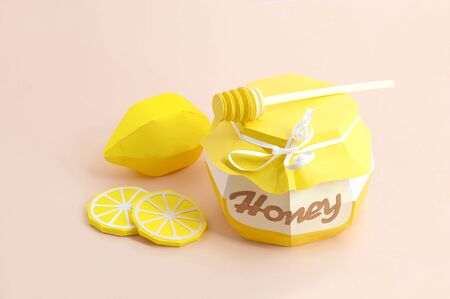 Paper pot with honey and dipper, whole lemon and slices. Paper art and craft. Volumetric handmade paper objects. Minimal healthy eating conceptの写真素材