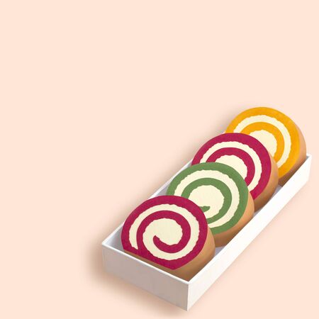 Paper roll cake with fruit marmalade made from strawberries, kiwi and orange. Box with paper slices of roll cake. Paper art and craft. Volumetric handmade paper objects. Minimal art food conceptの写真素材
